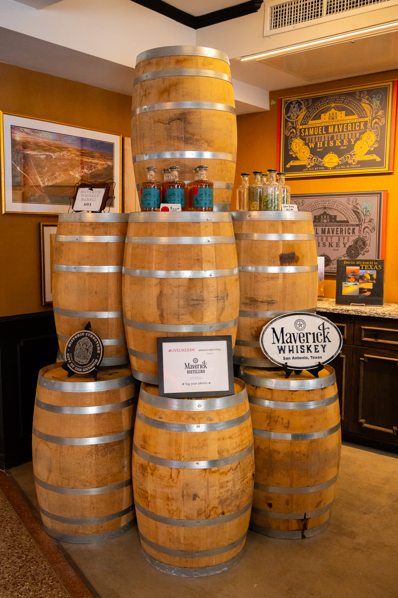 Stacked barrels in the tasting room, set with bottles and the Maverick Whiskey sign